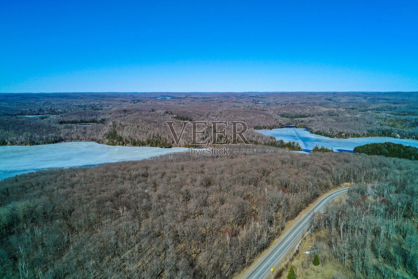 冻结的埃森湖,光秃秃的树木和哈利伯顿县的一条公路照片摄影图片