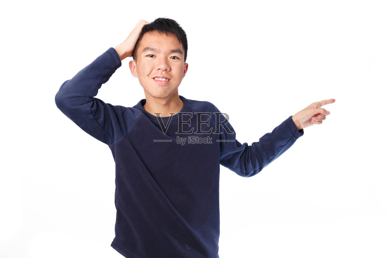 困惑的男孩搔着头,指着孤立的地方照片摄影图片