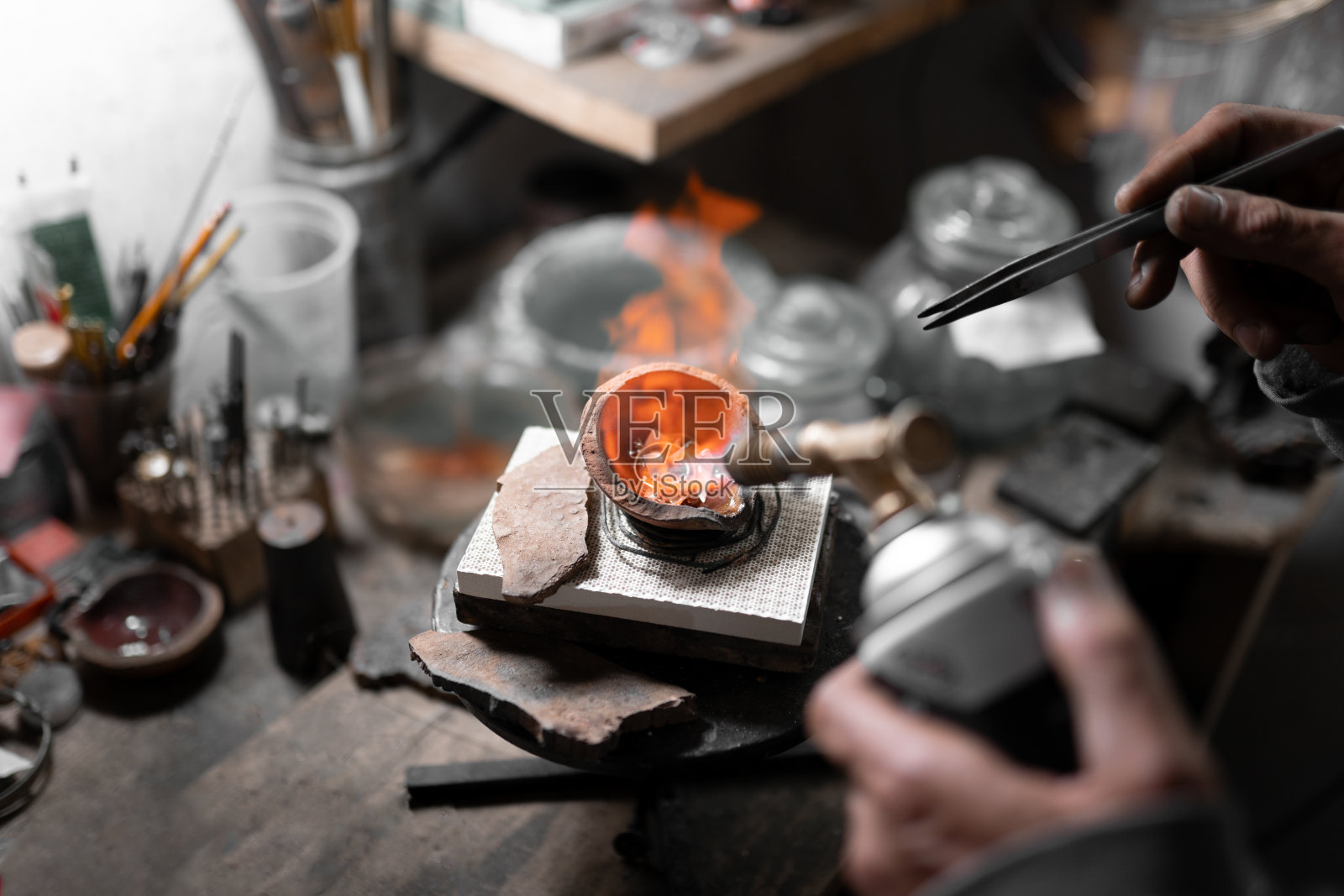 一位珠宝工匠正在用喷灯熔化一些银珠宝照片摄影图片