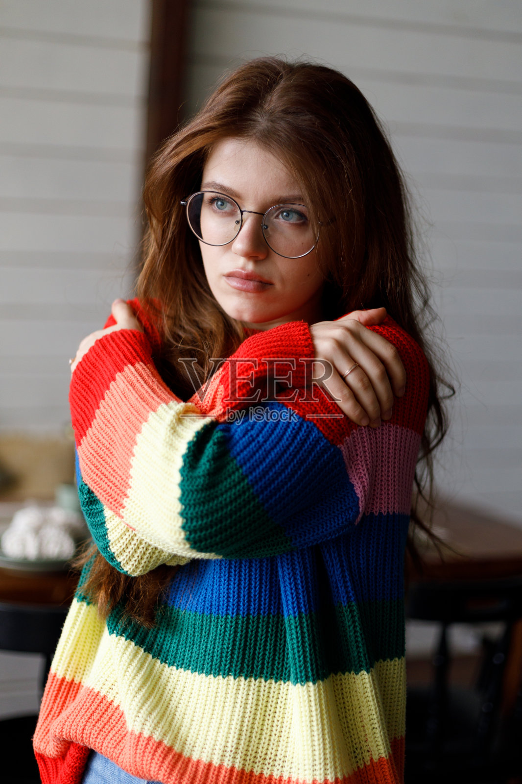 抑郁和悲伤。悲伤的年轻女子抱着自己在家里,忧郁和孤独。照片摄影图片