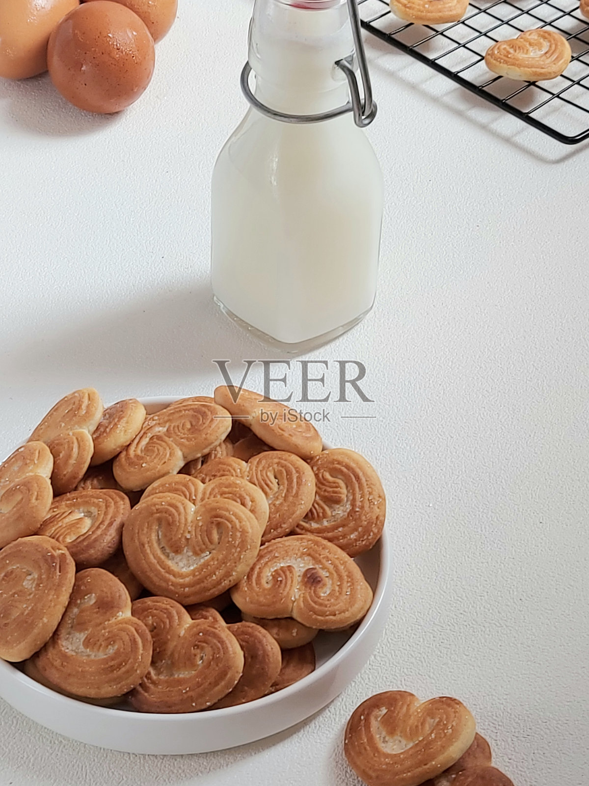 在饼干上撒糖,做成心形。照片摄影图片