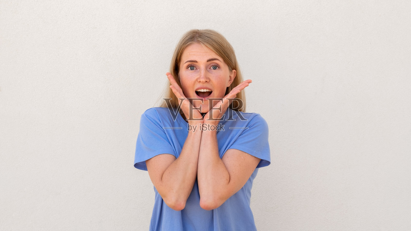 惊讶的年轻女子用手抱着她的脸照片摄影图片