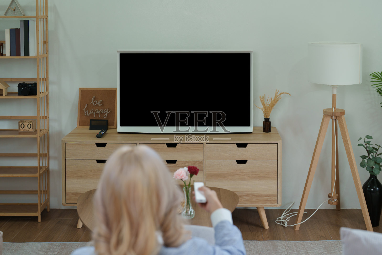 一个美丽的亚洲女人放松地看着黑屏电视,可以放文字或图片照片摄影图片