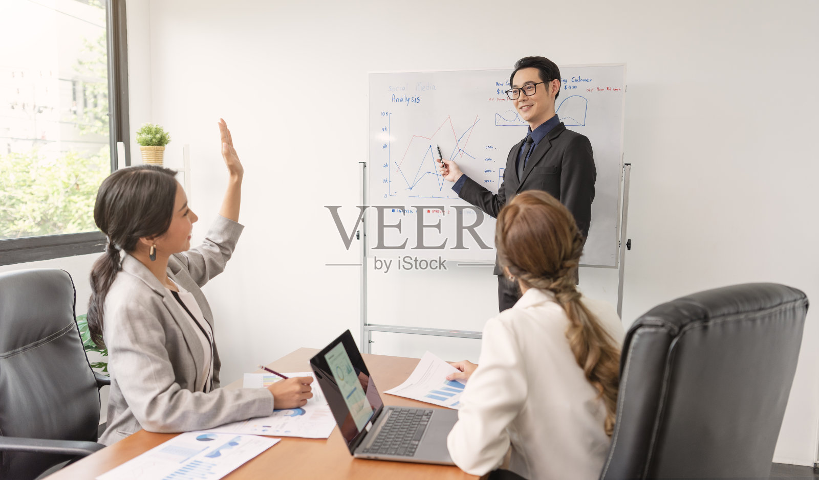 亚洲商人在办公室会议上向公司同事介绍他的工作。商务人士在会议上讨论公司的项目。照片摄影图片