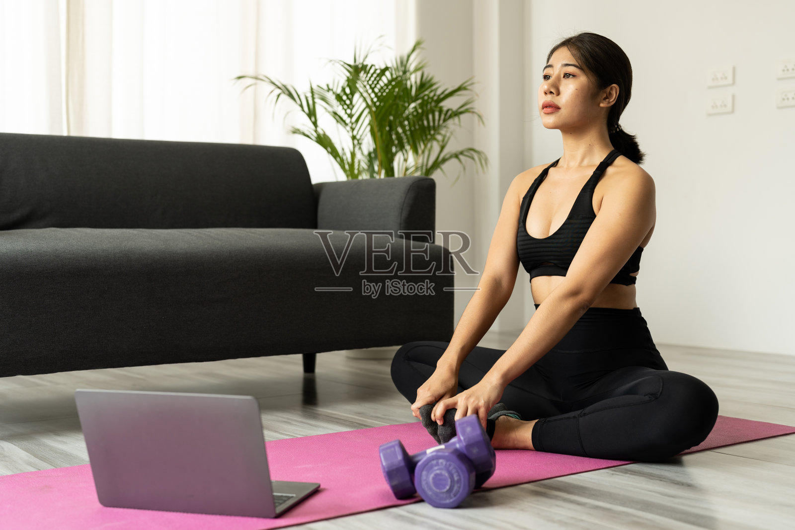 年轻美丽的亚洲女人练习瑜伽,在家看笔记本电脑上的视频-健身,锻炼的概念照片摄影图片