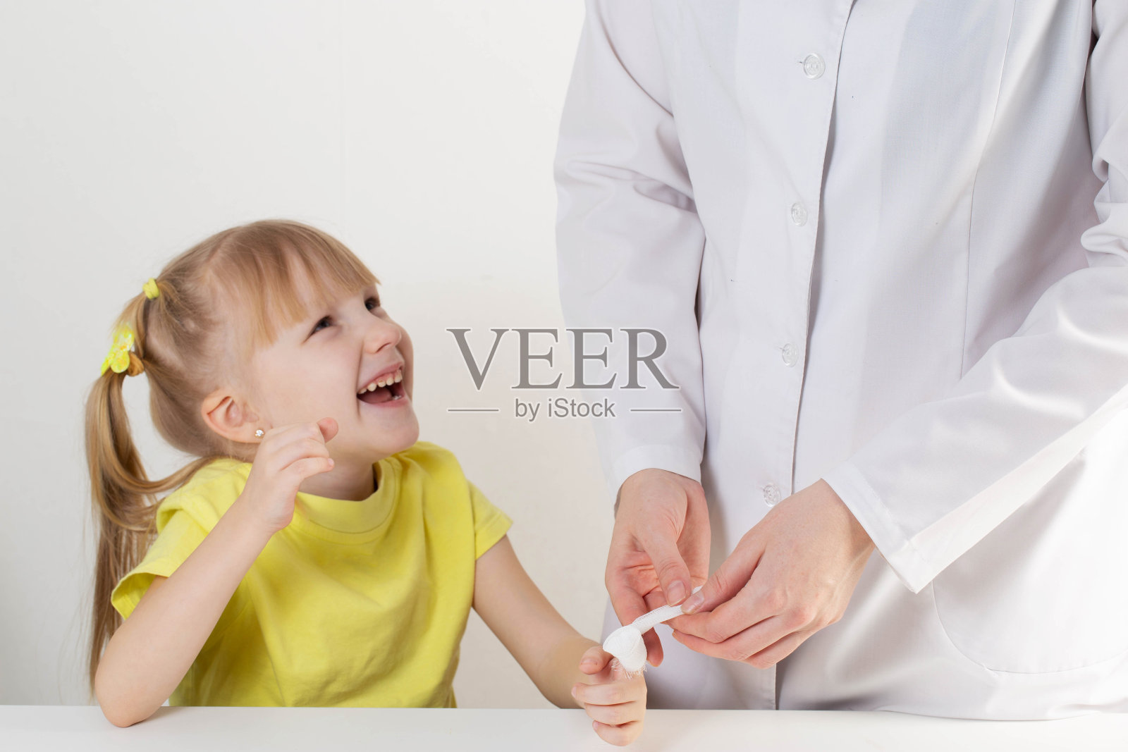 医生用绷带包扎伤口,孩子是一个5岁的女孩,儿科医学照片摄影图片