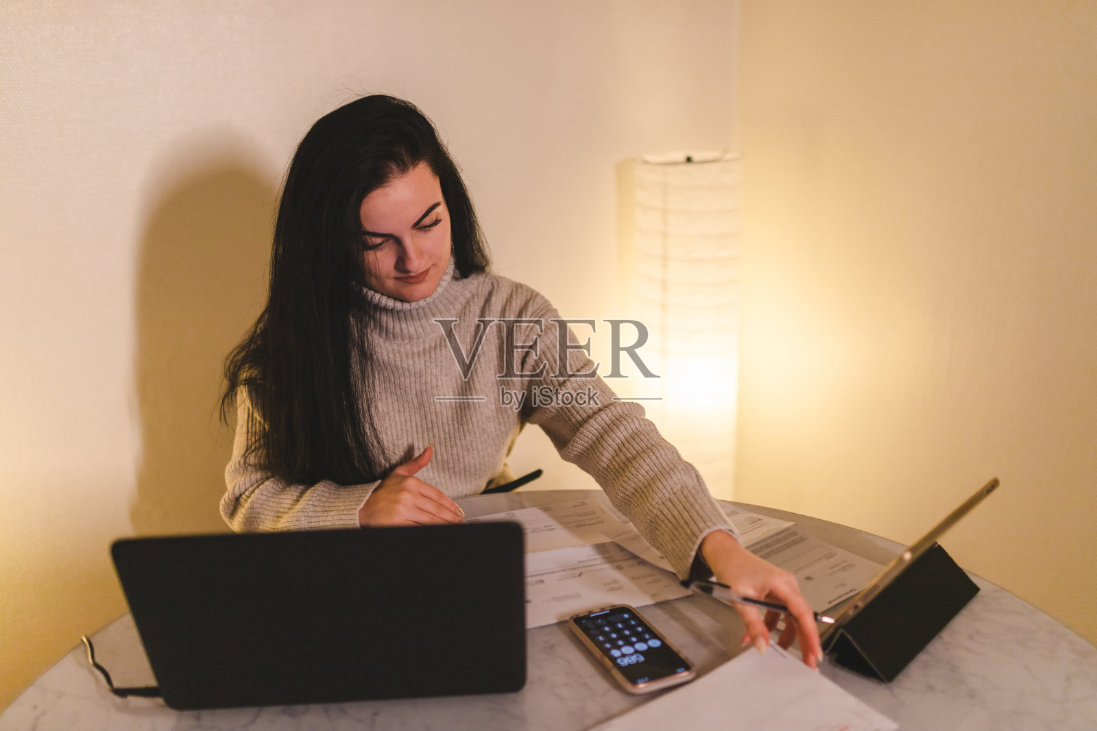 年轻的女人在家里做个人会计照片摄影图片