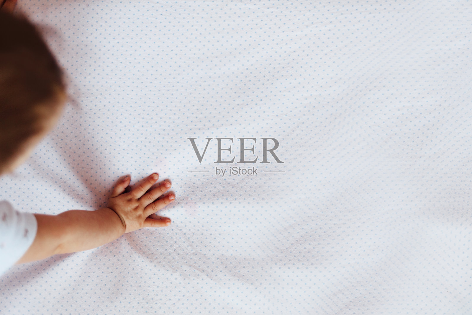 婴儿的手在床上的特写照片摄影图片