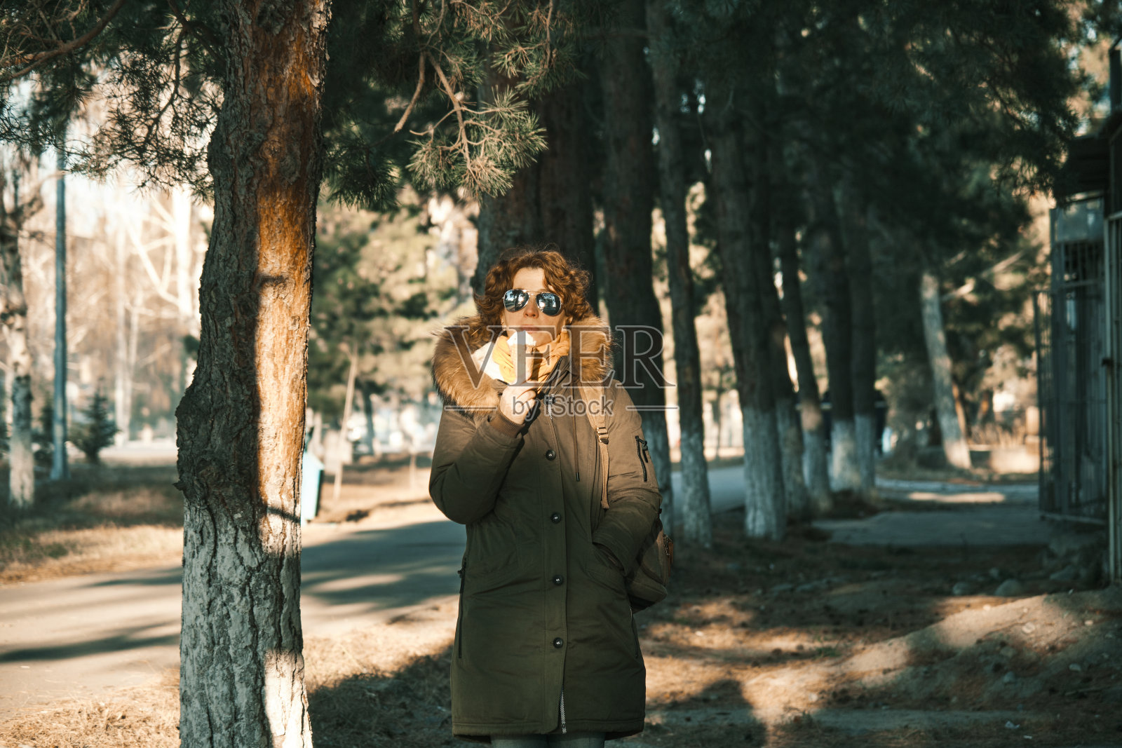 在冬天的小镇上,女人正在吃冰筒照片摄影图片