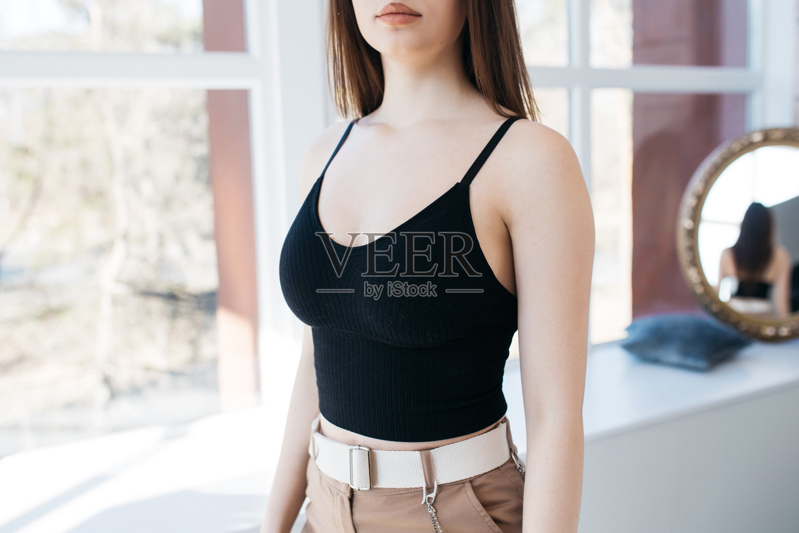 穿着时髦衣服的女孩。一个年轻女孩穿着一件上衣。照相馆里的模特。照片摄影图片