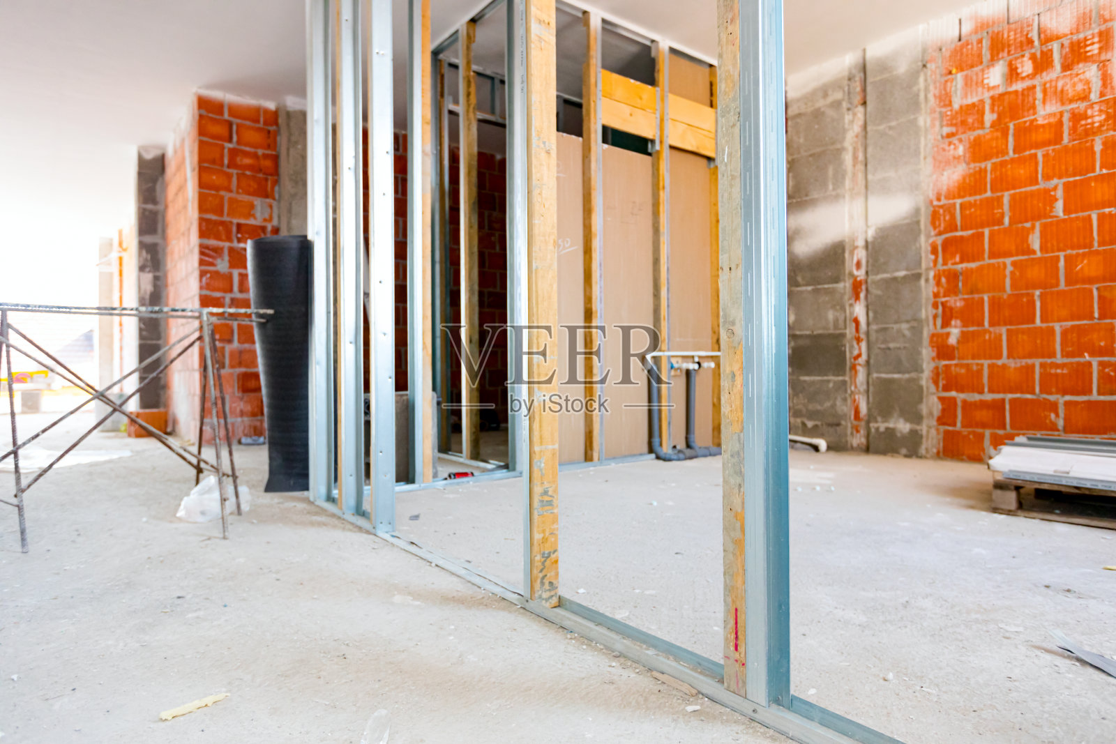 石膏板墙框架,安装垂直金属和木制型材,未完成的大厦正在进行的工作照片摄影图片