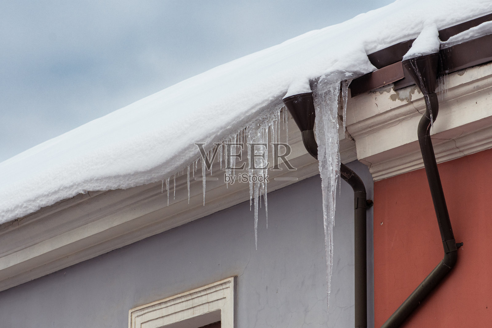 建筑物屋顶上悬挂的冰柱照片摄影图片