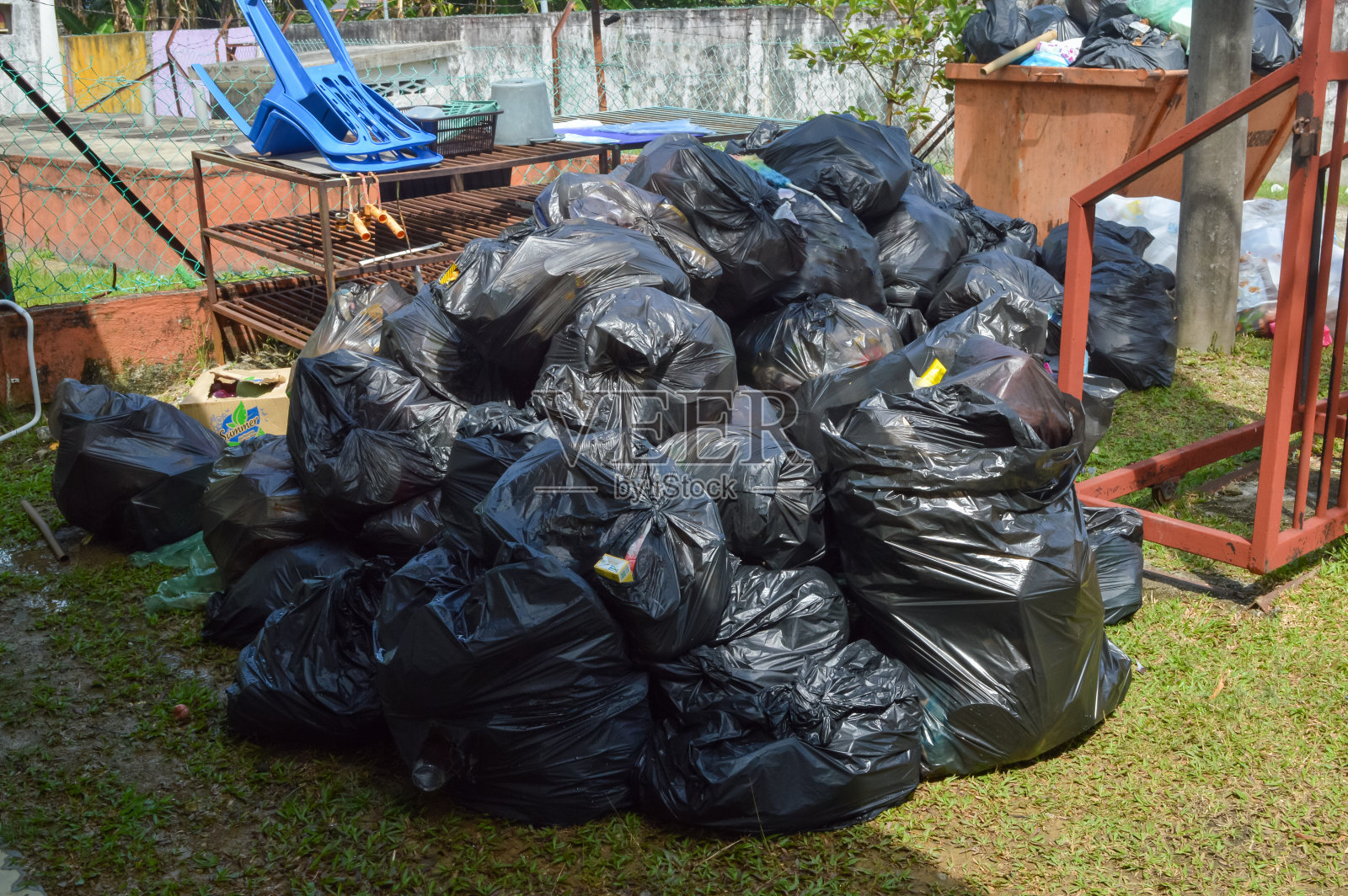 马来西亚巴生:2022年12月17日-垃圾场的一堆黑色塑料垃圾袋。照片摄影图片