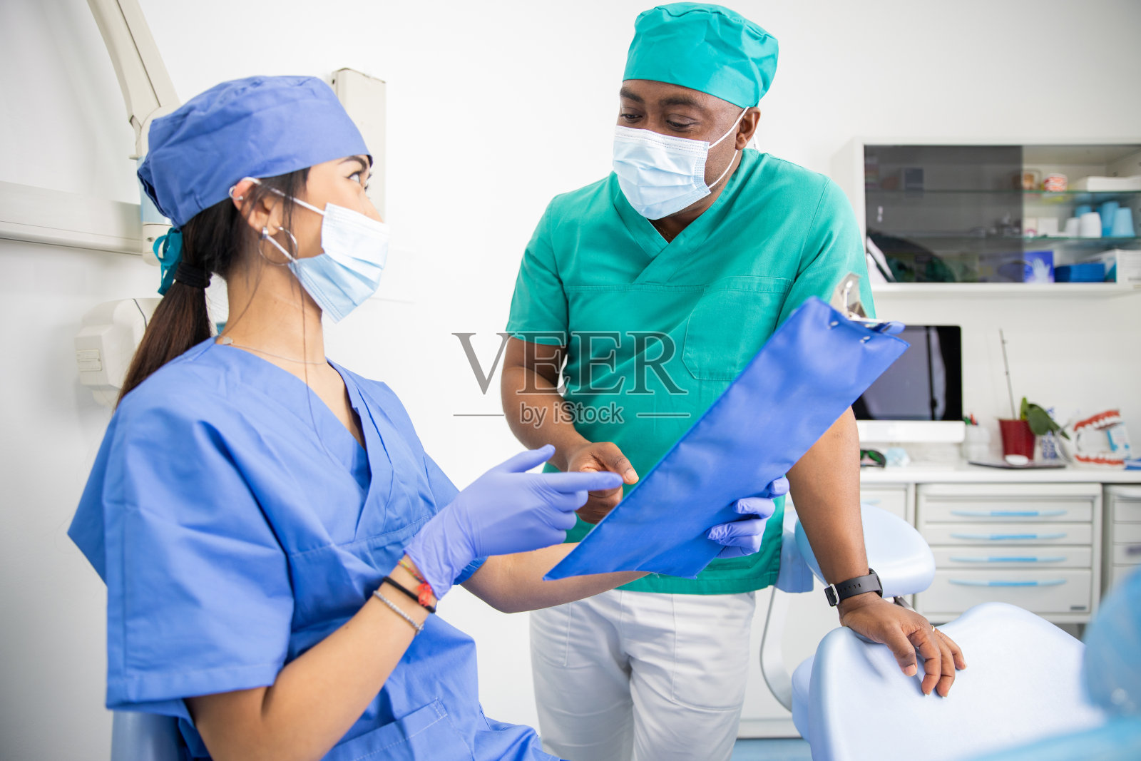 两名医生在诊所讨论,非洲和亚洲牙医在工作期间。照片摄影图片