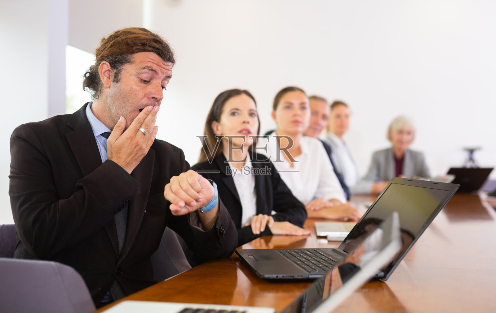 昏昏欲睡的商人在会议中打哈欠照片摄影图片