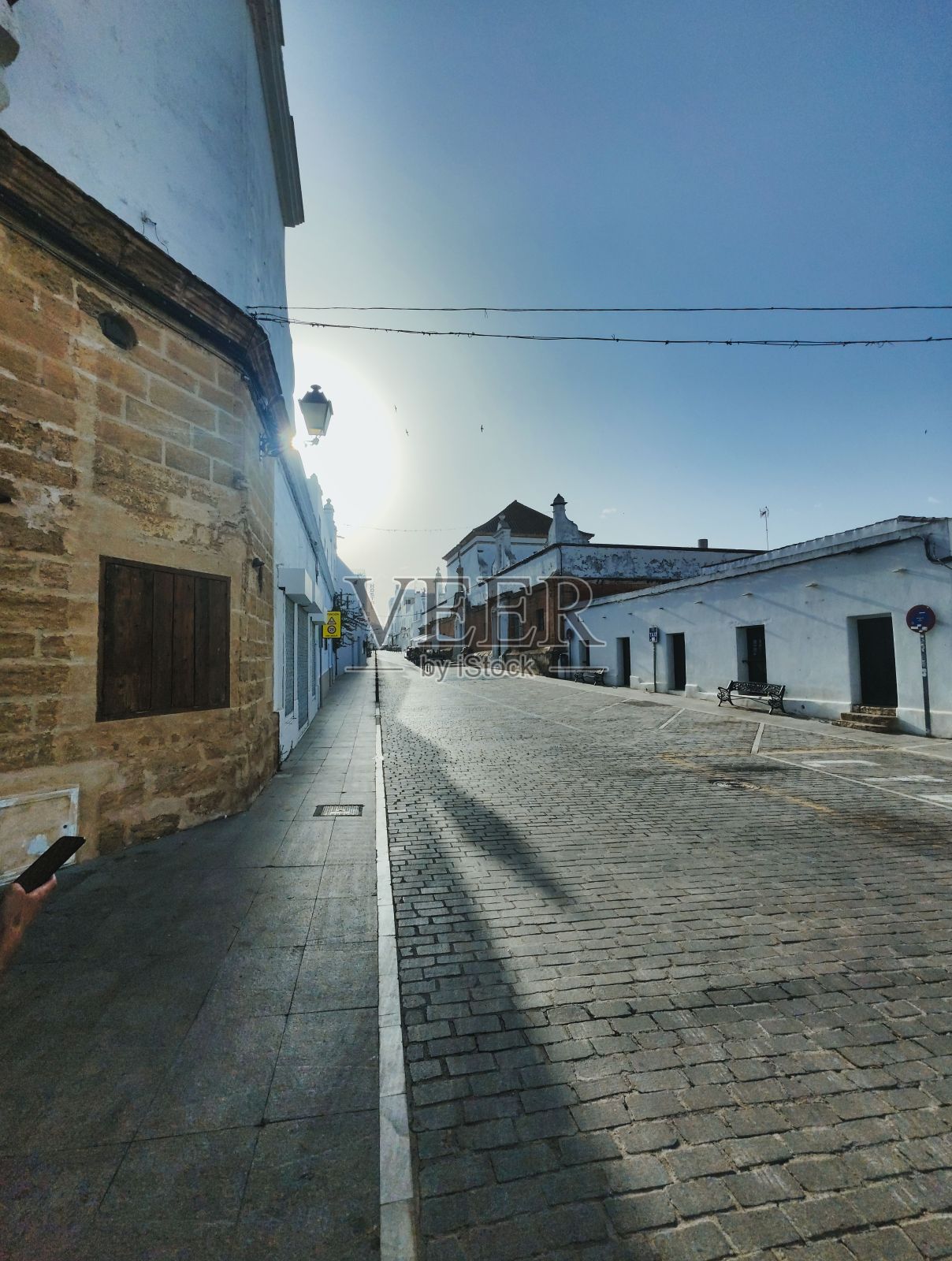 垂直的城市街道,有人行道,天空中有阳光照片摄影图片