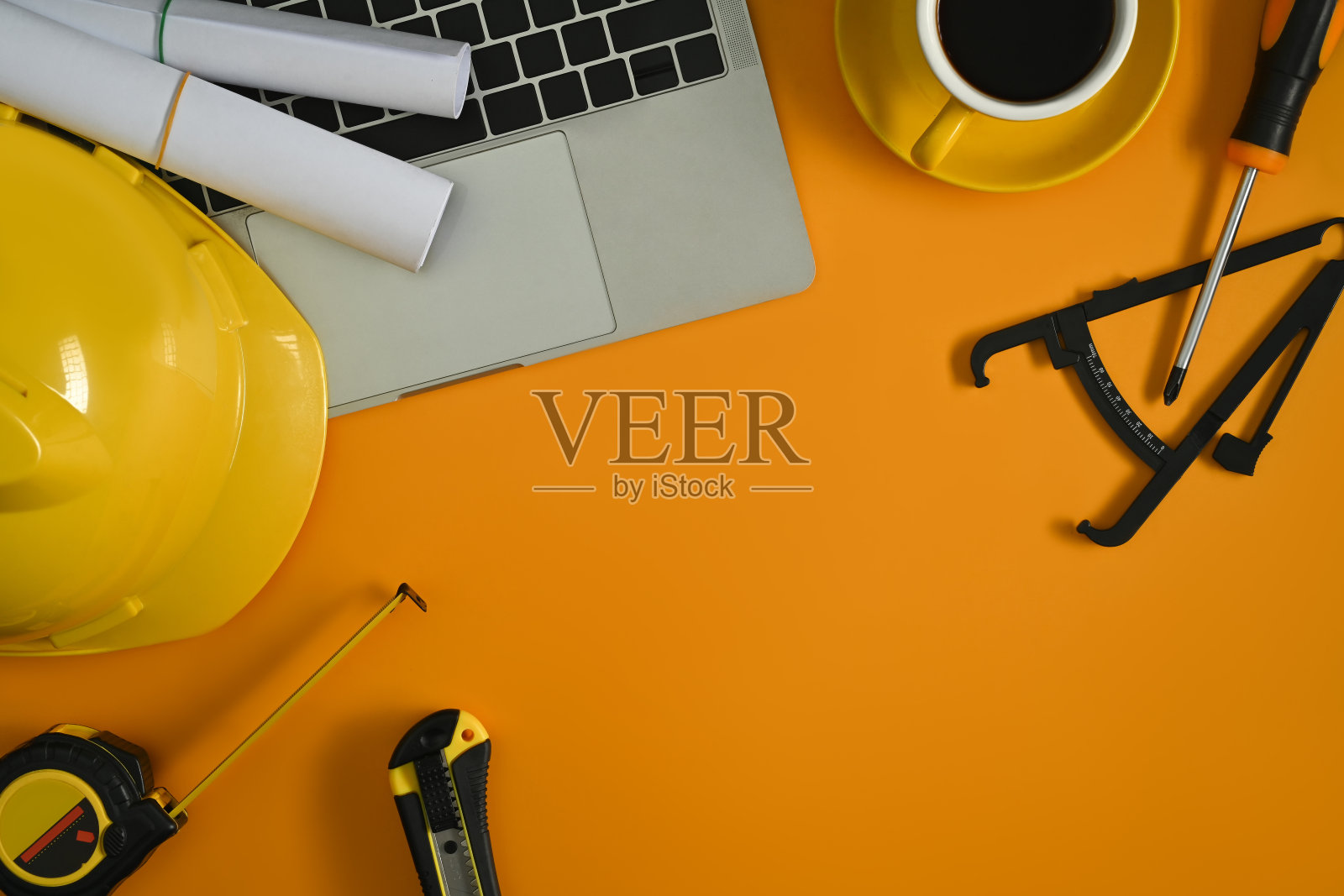 笔记本电脑的顶视图,蓝图和黄色背景上的安全帽。复制文本空间。照片摄影图片