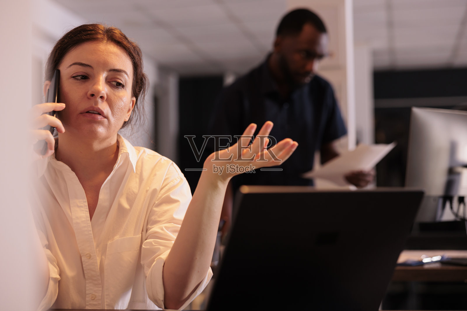 员工在办公室用智能手机讨论研究成果照片摄影图片