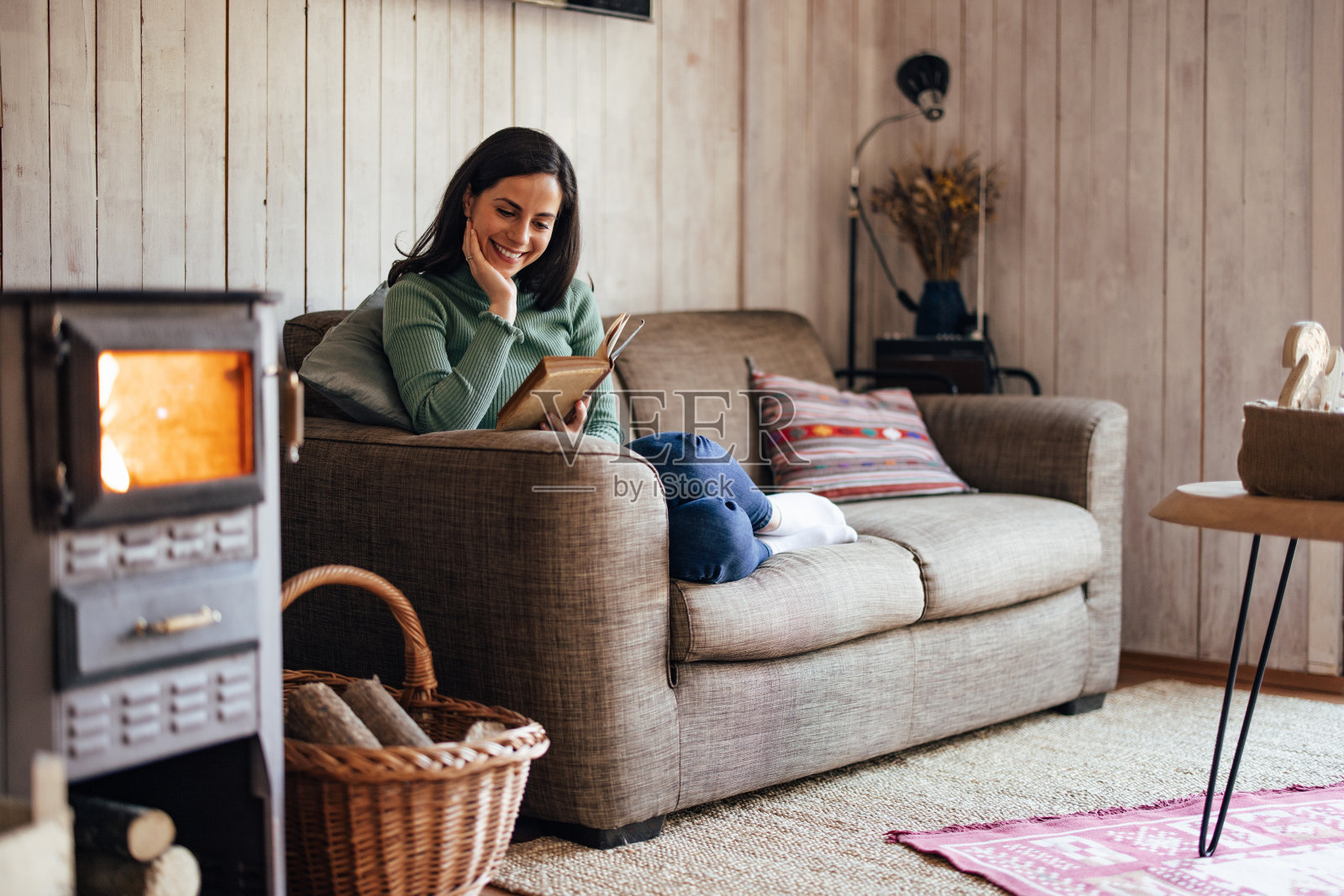 美丽的女人享受自己在家里,看书。照片摄影图片