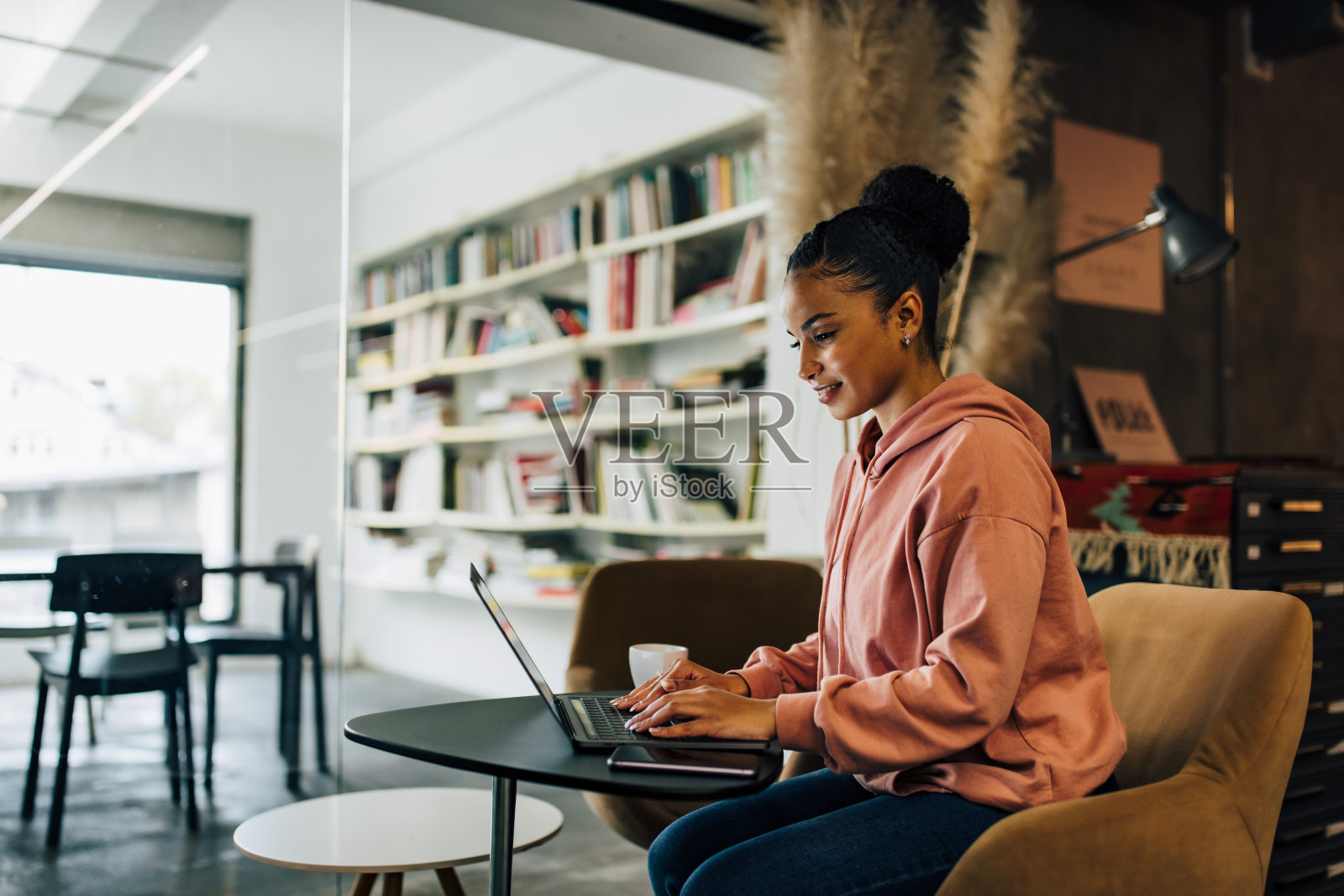 非洲女商人坐在家庭办公室,使用笔记本电脑。照片摄影图片