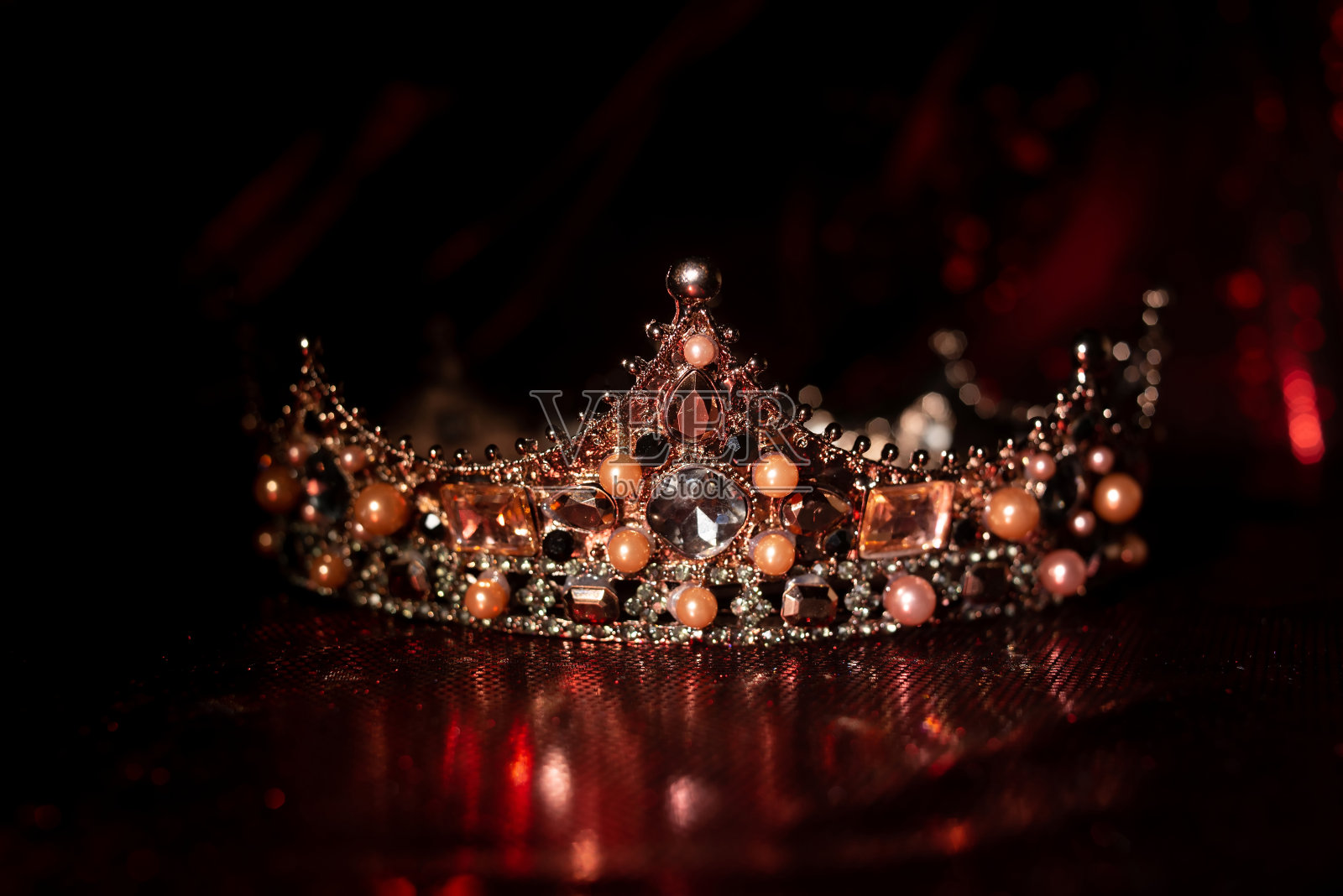 皇家皇冠与珍贵的宝石在红色豪华面料背景。国王和王后照片摄影图片