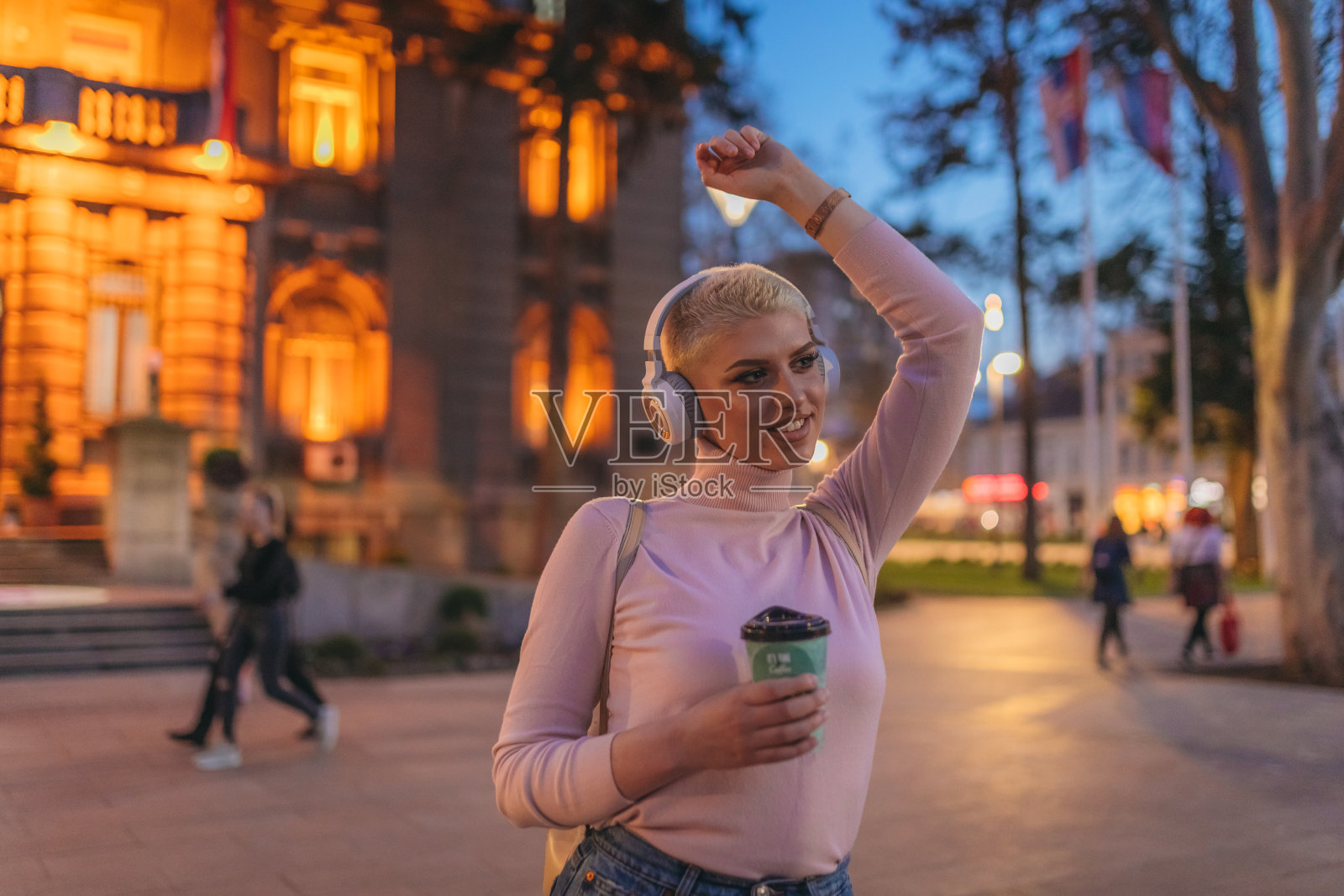 微笑的白人妇女在户外听音乐时微笑照片摄影图片