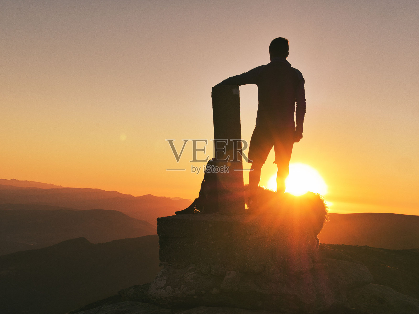 一个男人站在山顶上欣赏日出景象的剪影照片摄影图片