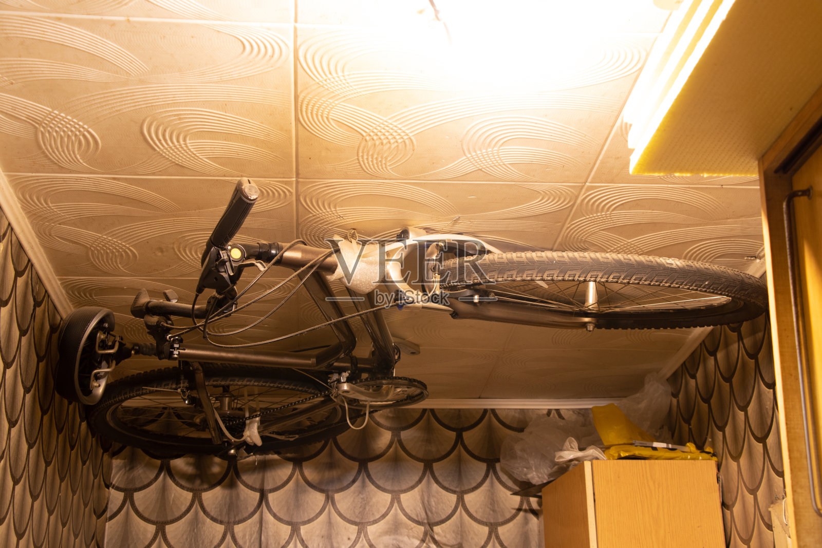 自行车安装在天花板上的小住宅公寓有限的空间,自行车储存在家里照片摄影图片