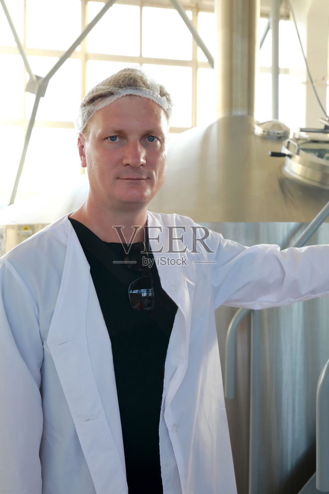 穿着制服的游客在啤酒厂摆姿势照片摄影图片