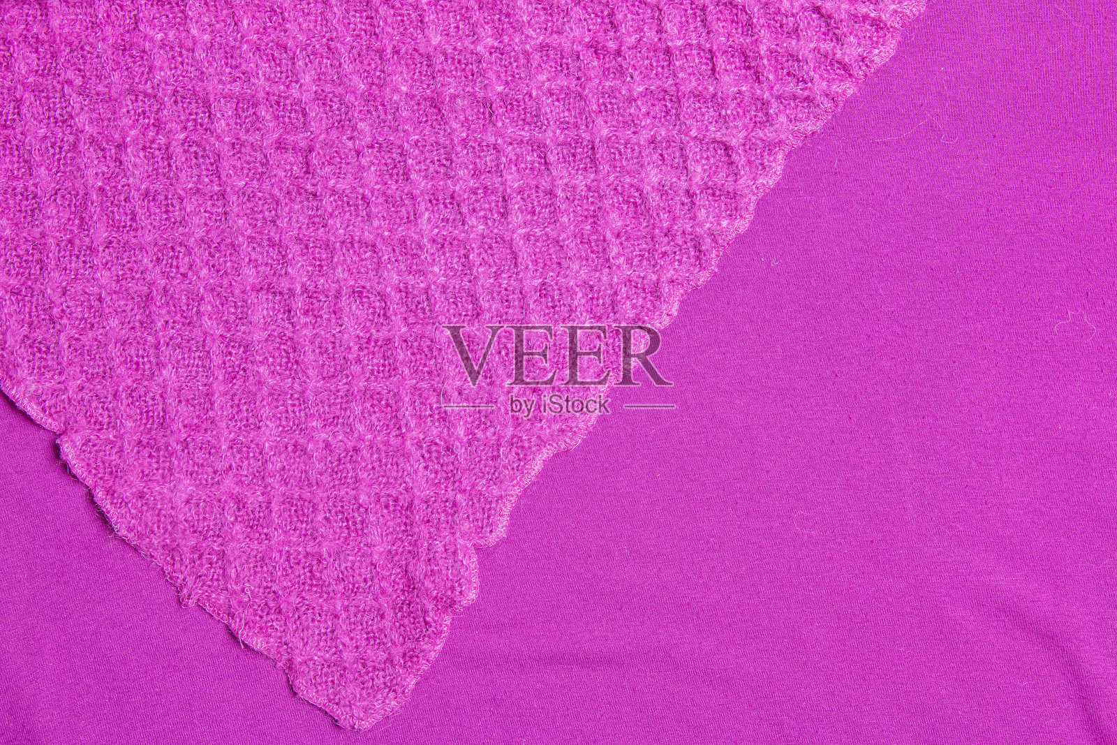 淡紫色针织地毯特写。淡紫色背景上的纺织品纹理。详细的暖纱背景。天然羊毛面料,毛衣碎片。照片摄影图片