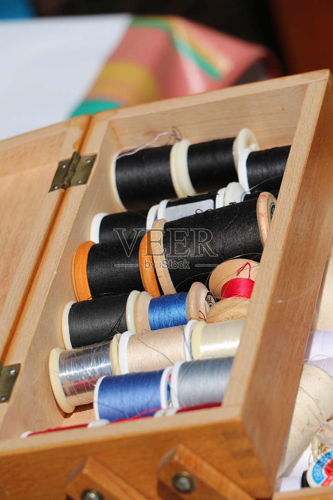 一个有许多缝纫线卷的木箱的特写照片摄影图片