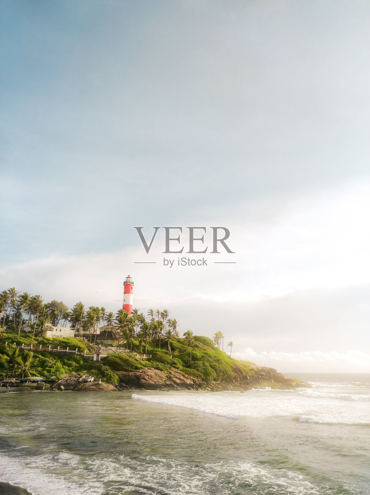 宁静海滩上常绿悬崖上的灯塔风景垂直拍摄照片摄影图片