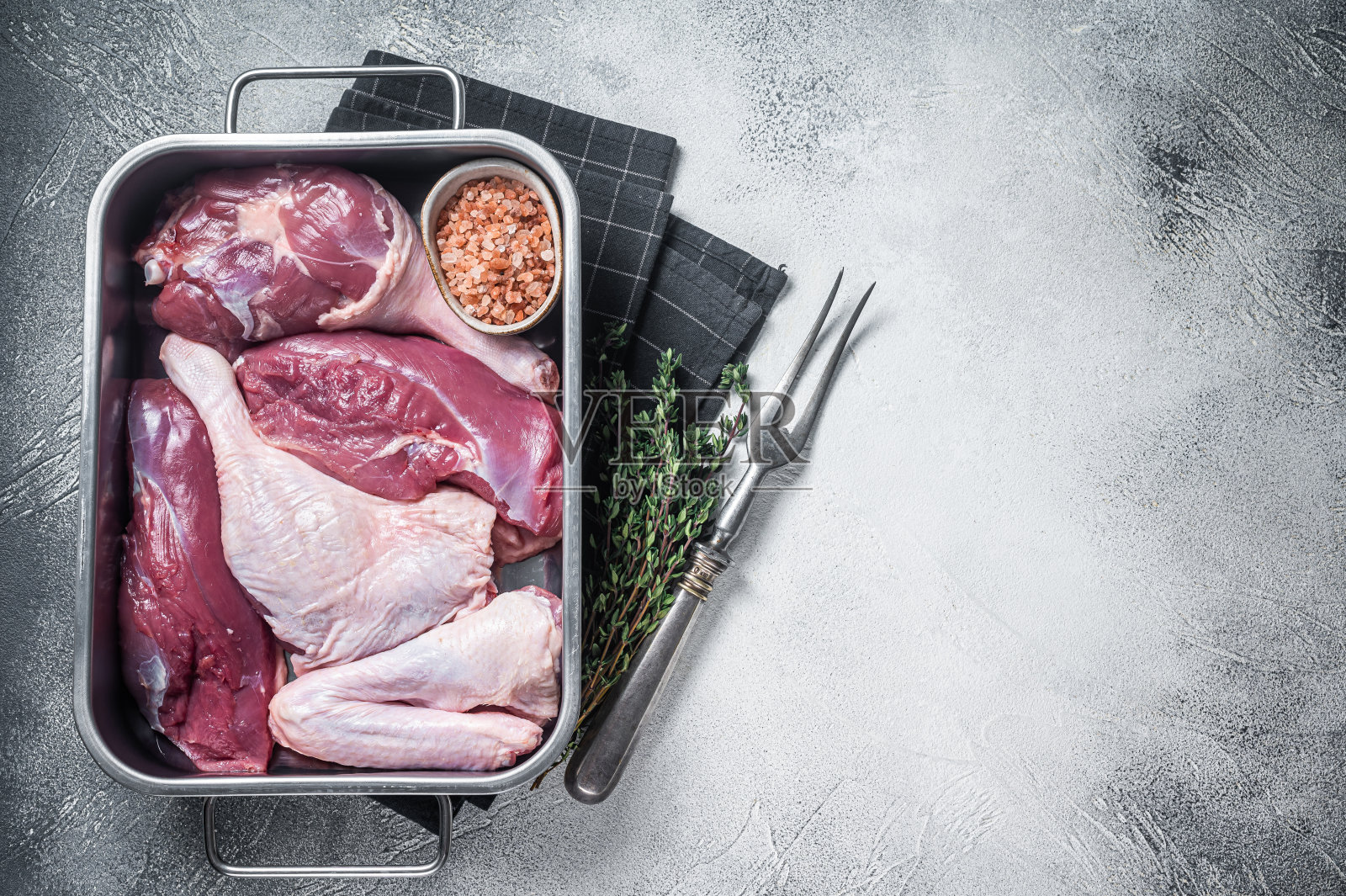 生鸭部分,新鲜的鸡胸肉,鸭腿,鸭翅放在厨房托盘里。白色背景。前视图。本空间照片摄影图片