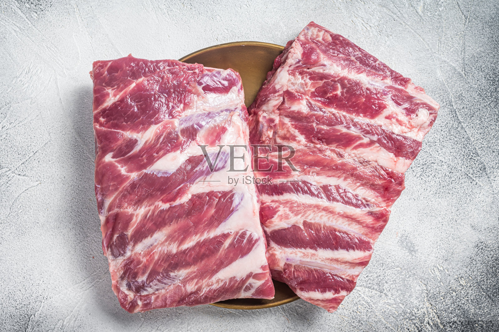 一排生猪肉排骨。白色背景。俯视图照片摄影图片