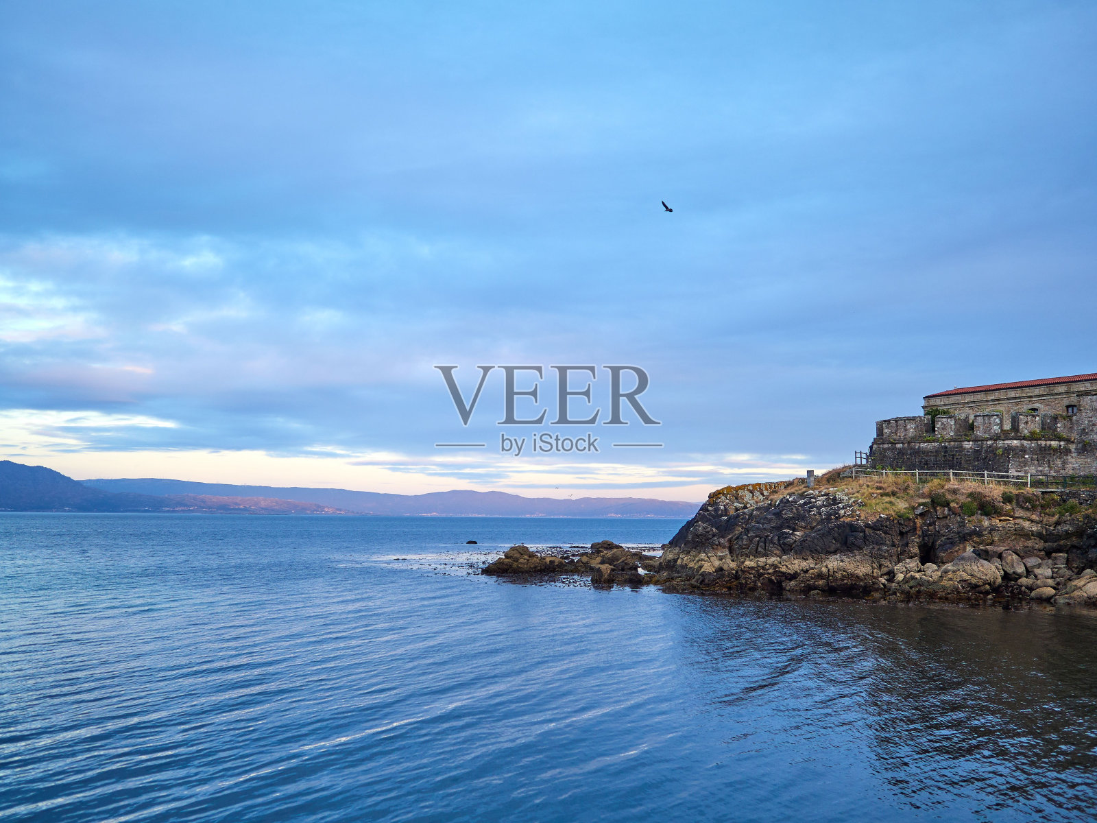 宁静的海景被岩石海岸捕捉到日落的天空照片摄影图片