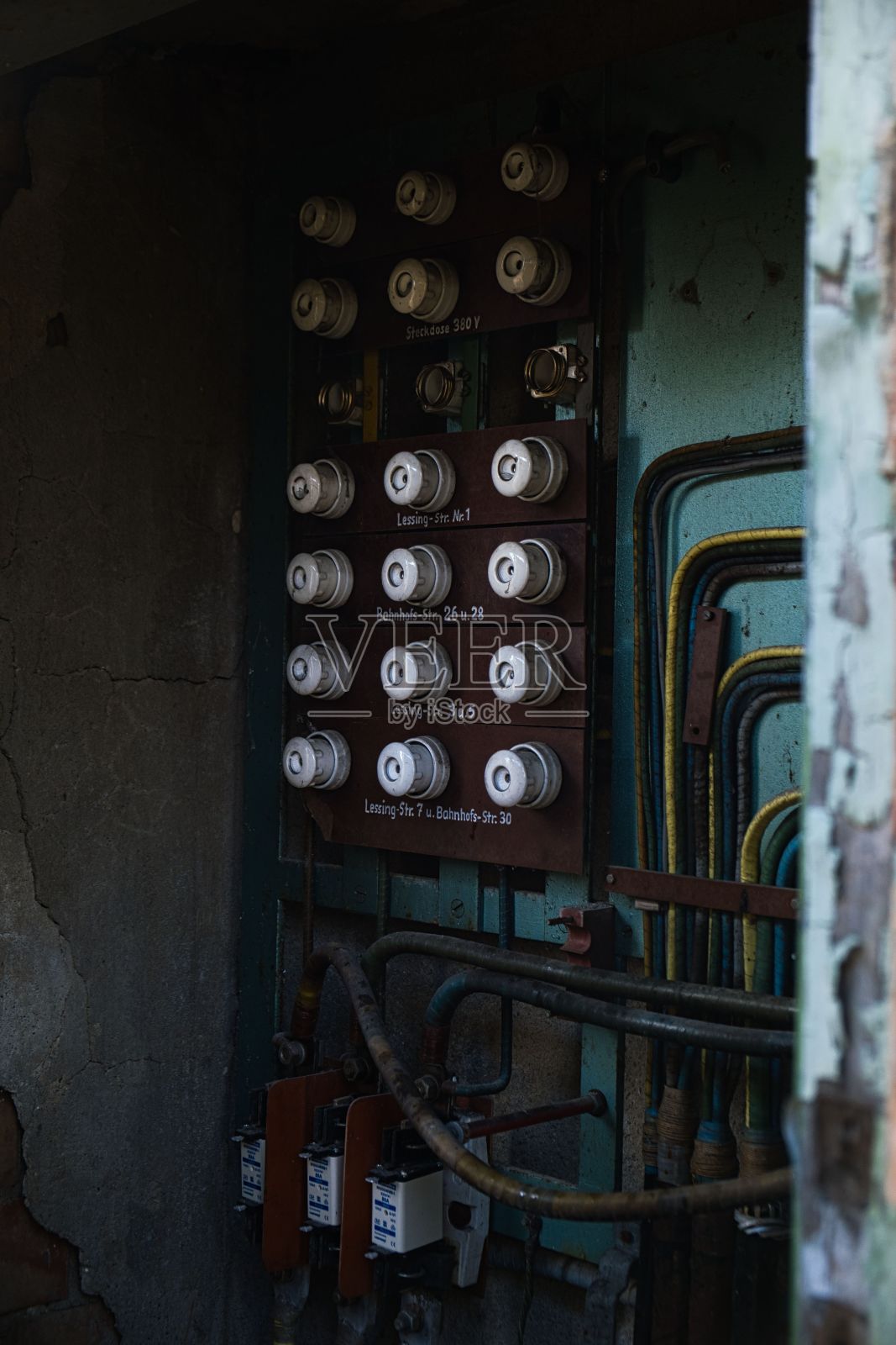 垂直拍摄的旧保险丝板安装在肮脏的墙壁照片摄影图片