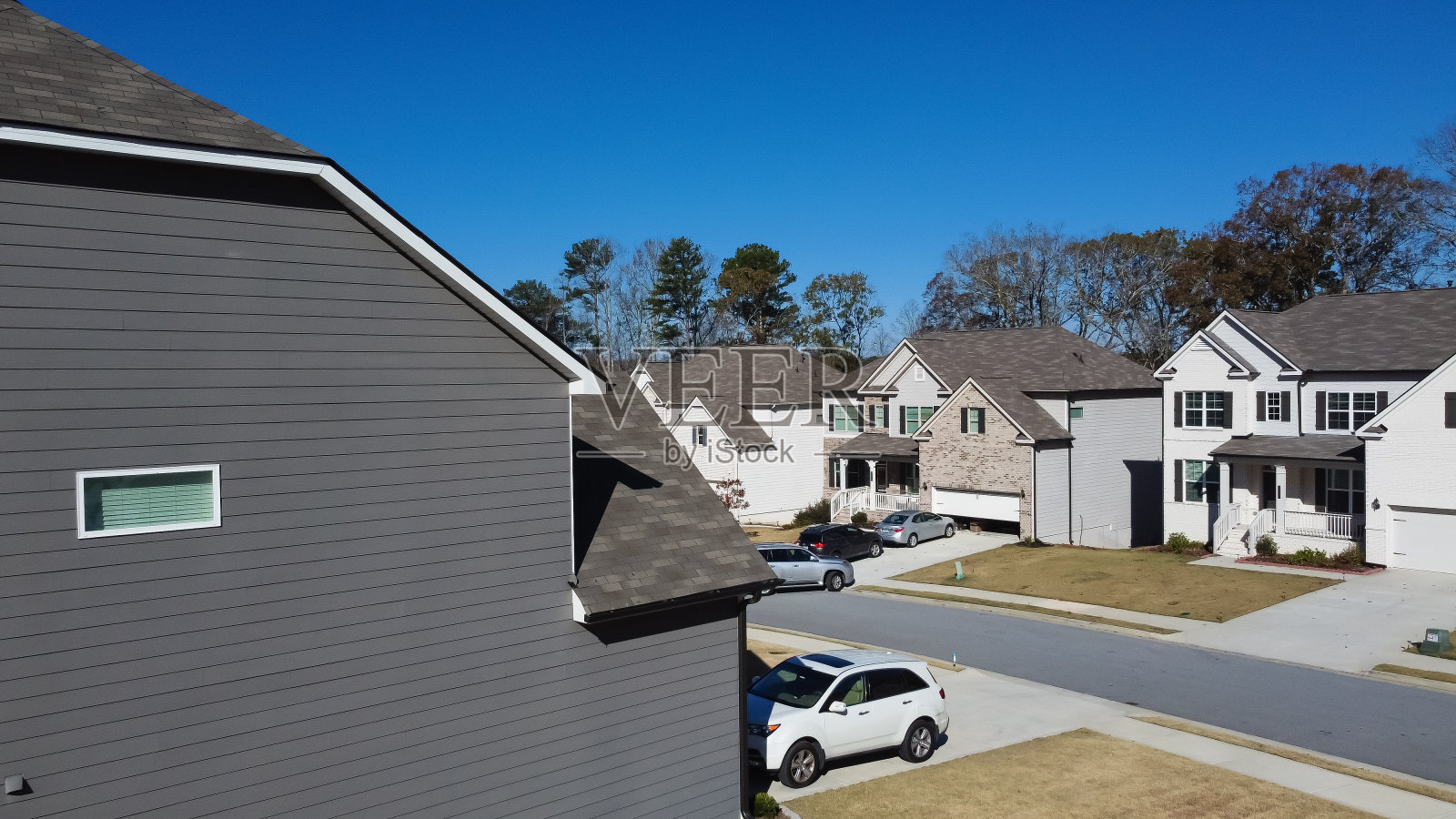 美国佐治亚州亚特兰大市郊区新开发住宅小区两层房屋的山墙屋顶和木壁板的鸟瞰图特写照片摄影图片