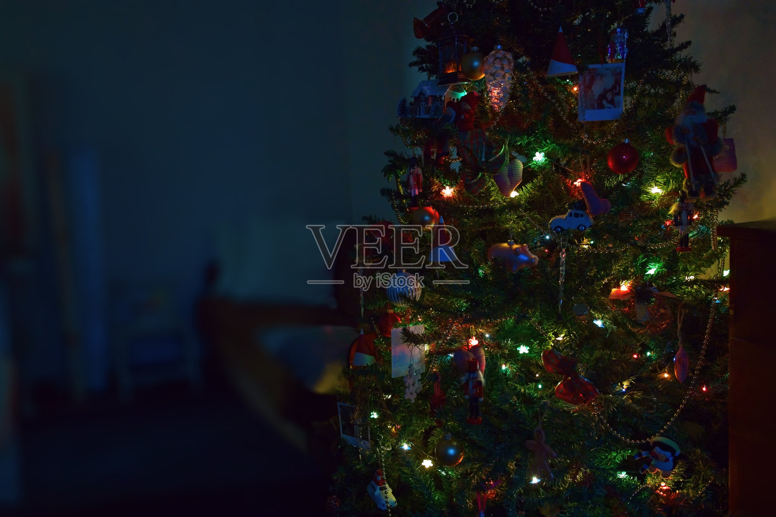 用彩灯装饰圣诞树,在黑暗的背景上复制空间照片摄影图片