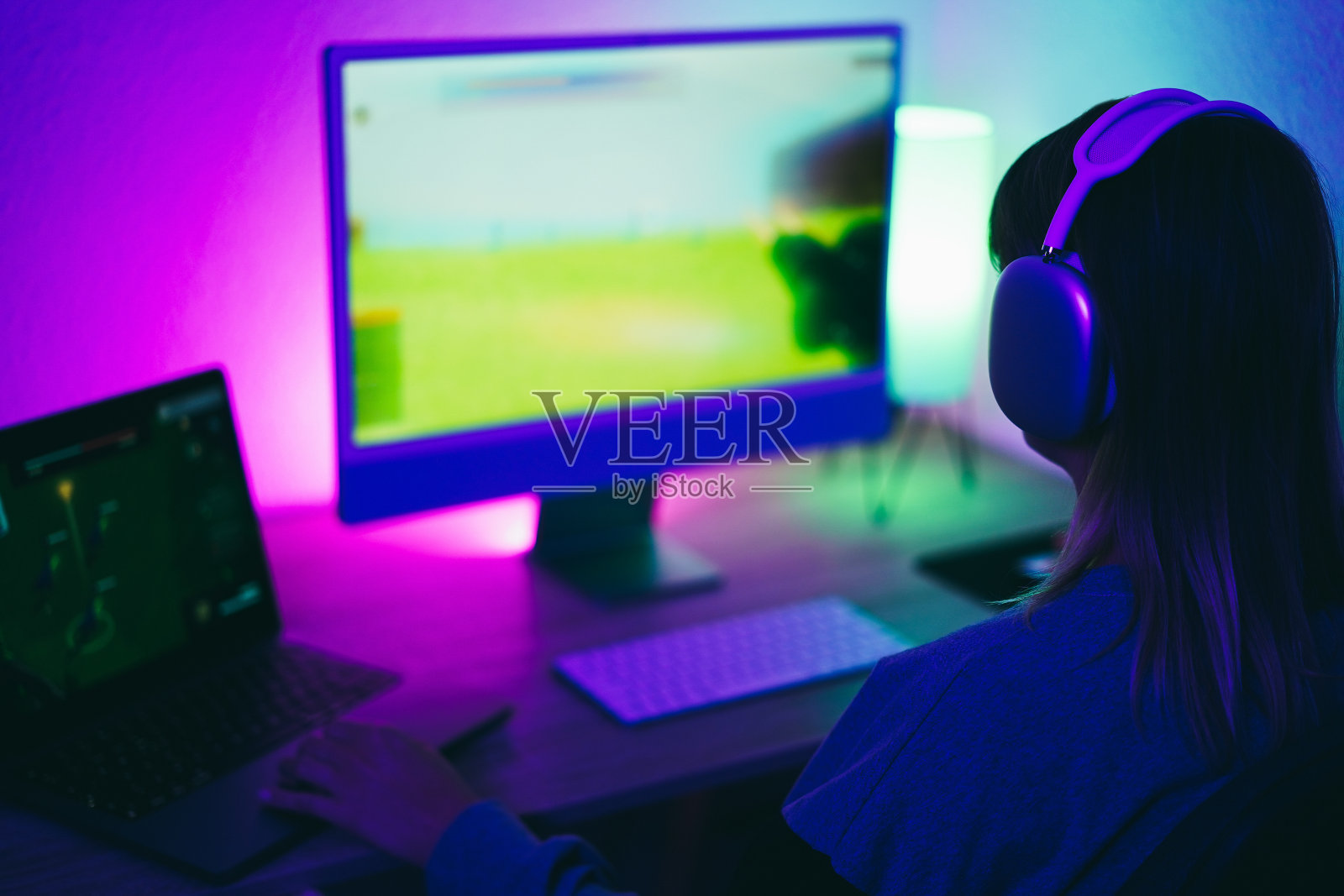 游戏玩家女孩玩战略游戏,同时流媒体在线-专注于耳机照片摄影图片