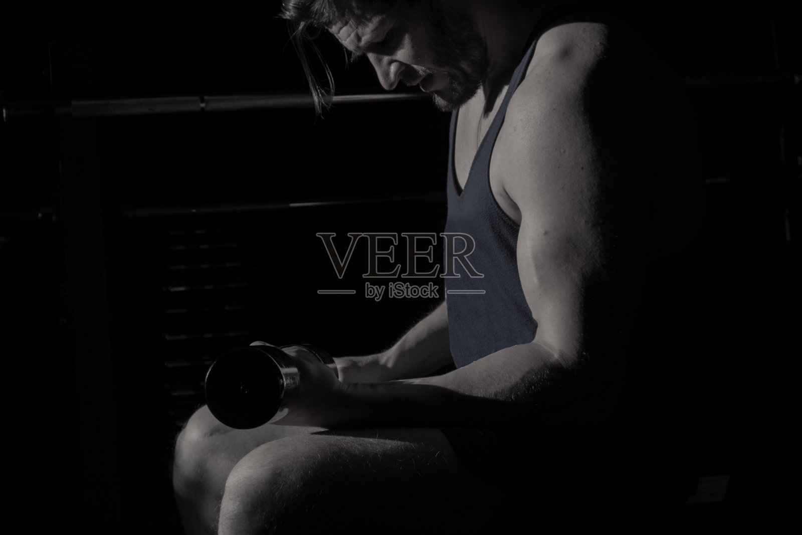 体育馆里的运动员。强壮的手拿着哑铃。健康的生活方式,男性的力量和耐力。照片摄影图片