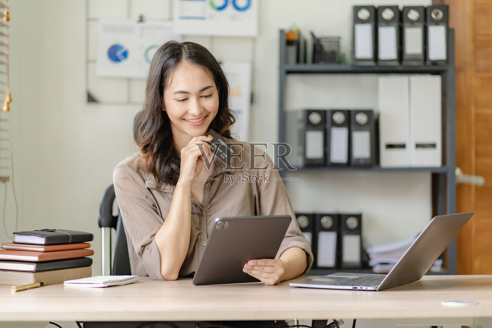 快乐的年轻亚洲女子在家网上购物她拿着信用卡,使用平板电脑。网上银行支付通信网络互联网无线应用照片摄影图片