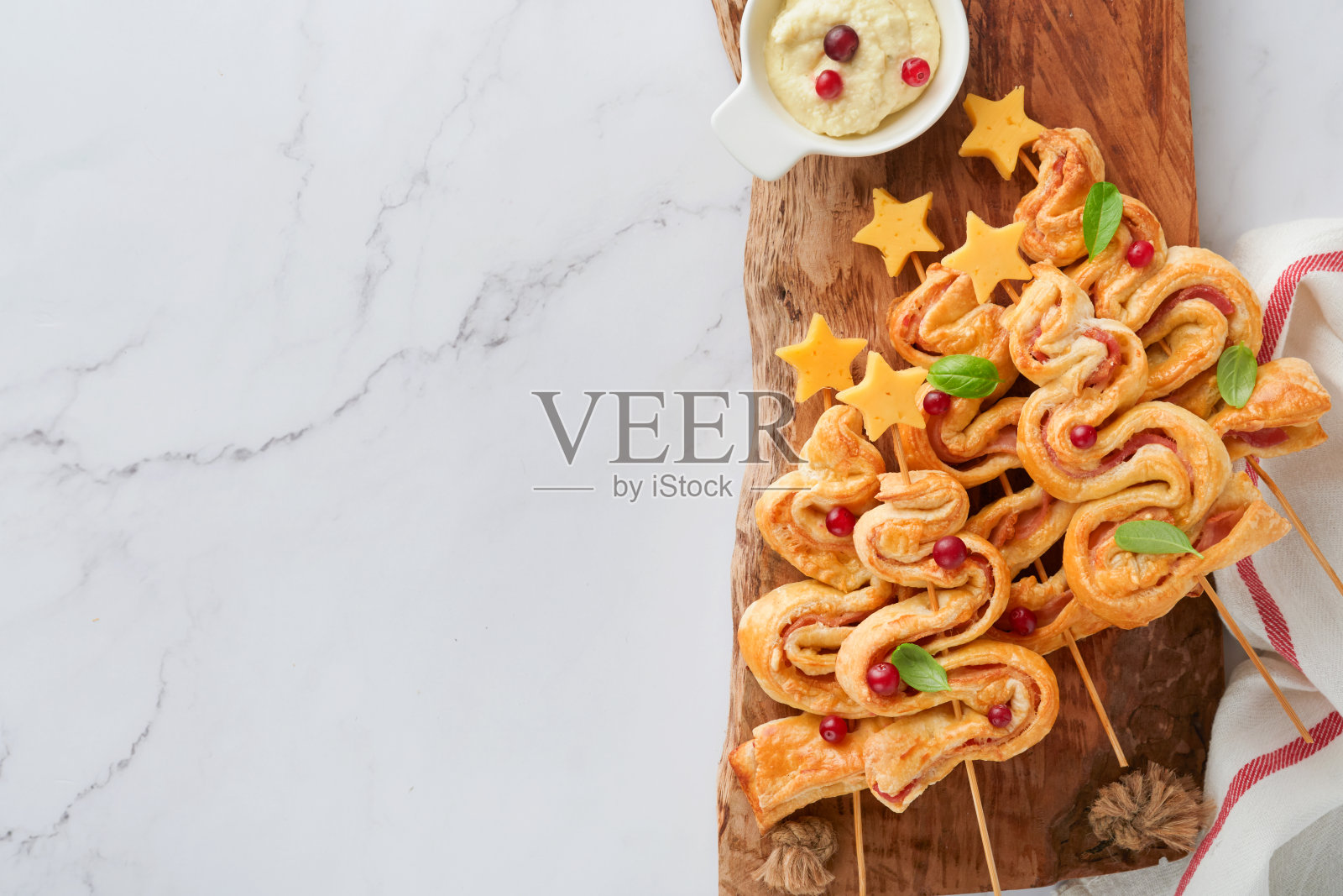 圣诞节或新年的开胃菜。圣诞树形状的酥皮面包加上奶酪和火腿。一组圣诞树形状的木板。圣诞或新年晚餐的节日点子。前视图。照片摄影图片