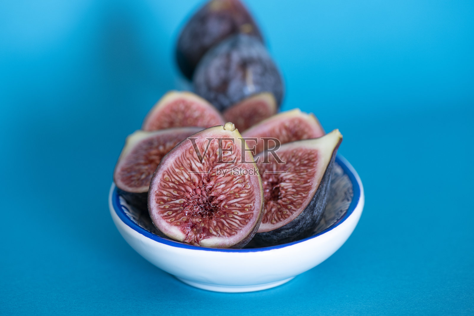 装饰盘里有很多黑色的无花果,有的整颗的,有的半颗的,深蓝紫色的美味水果照片摄影图片