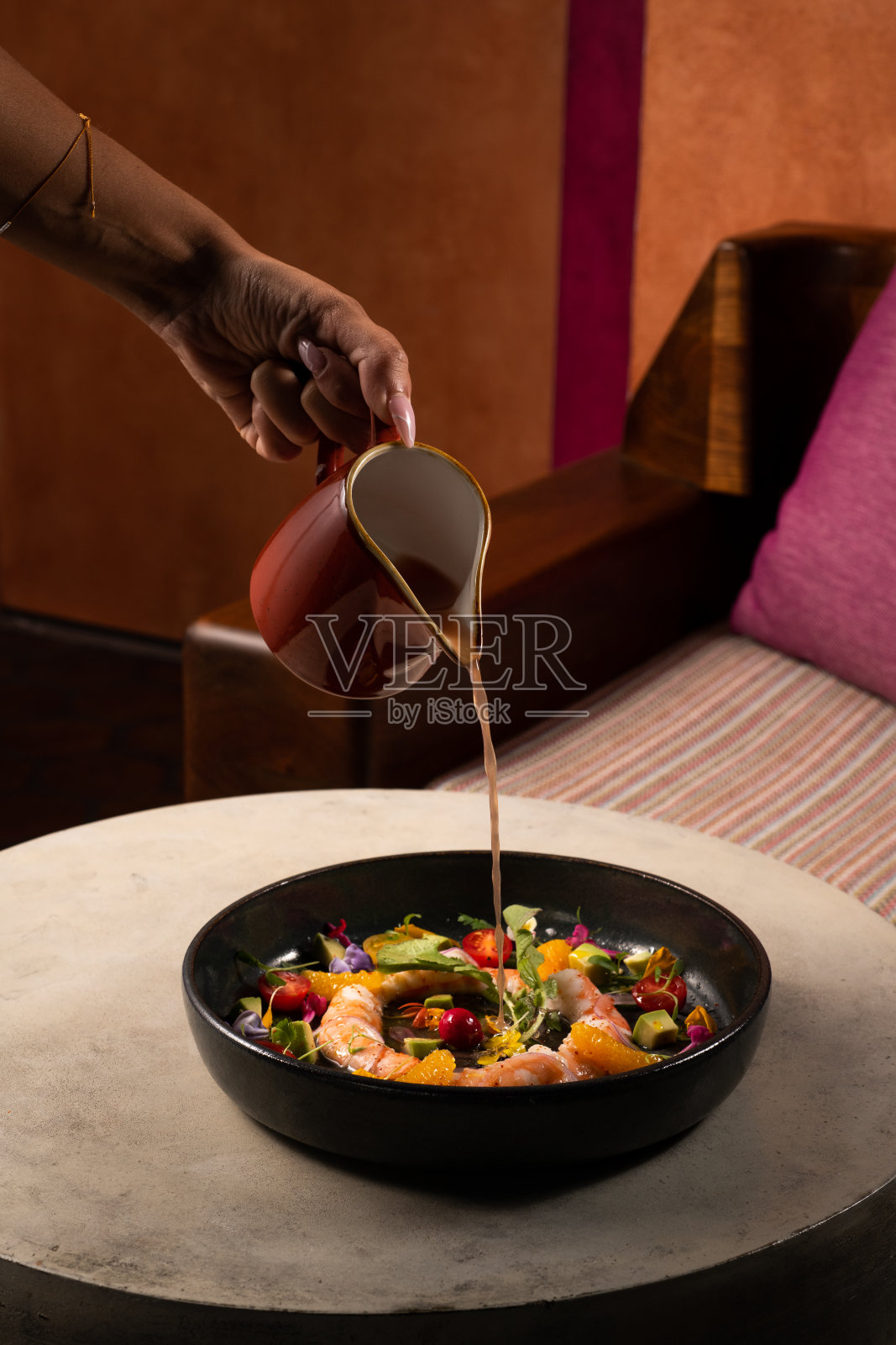 酒红色餐桌上的鲜虾沙拉。照片摄影图片