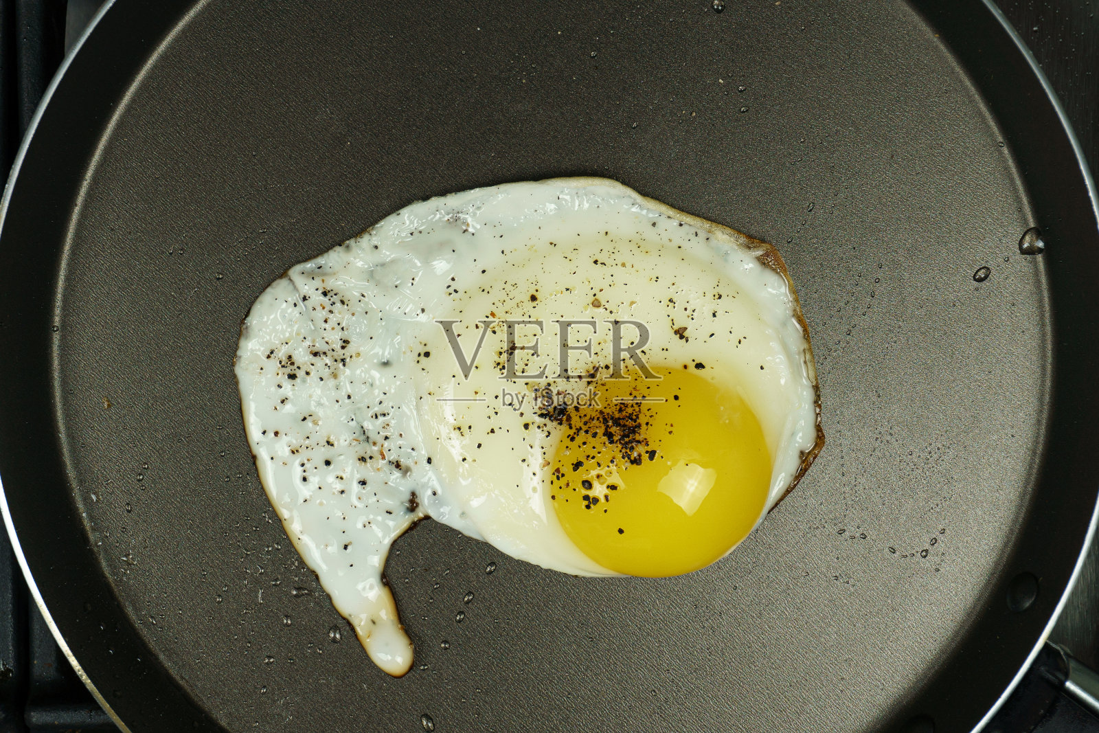 在煎锅里煎蛋。特写镜头照片摄影图片