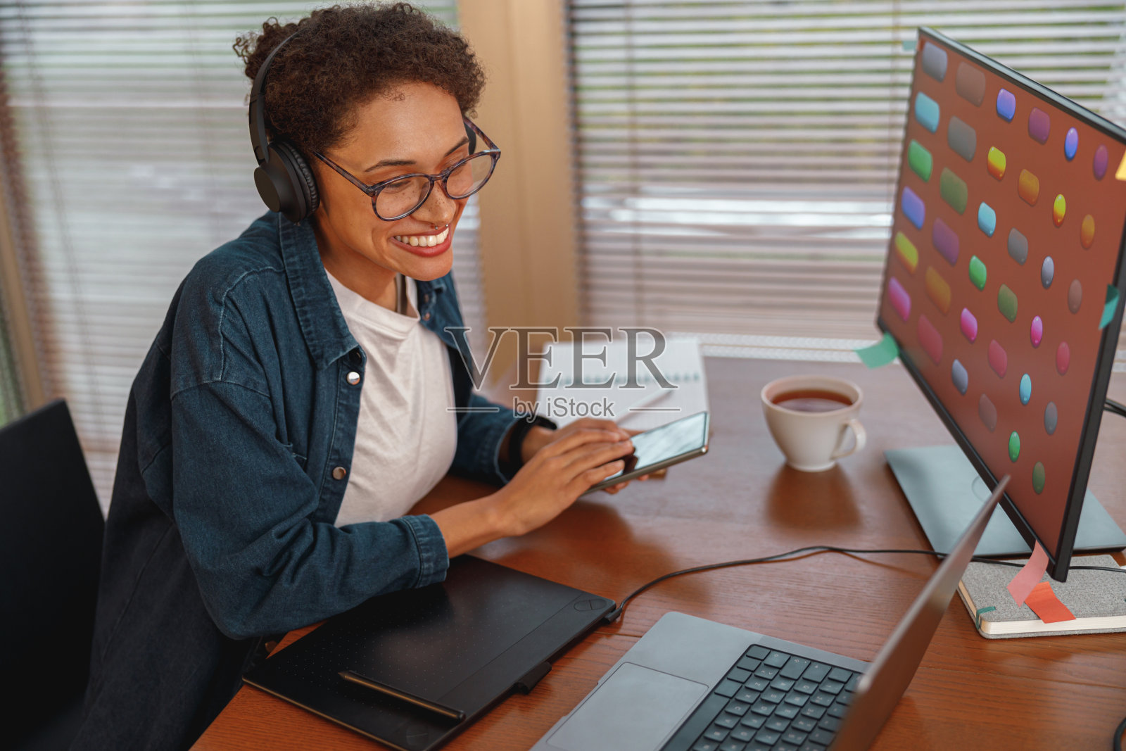 女平面设计师在家里办公的时候使用智能手机照片摄影图片
