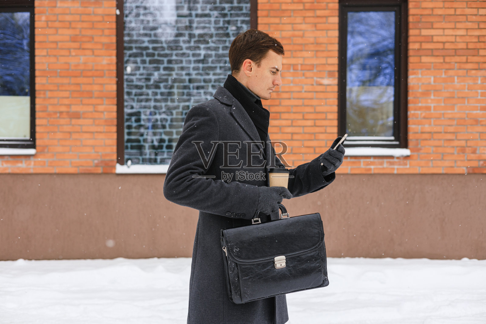 男经理带着随员在城里浏览智能手机照片摄影图片