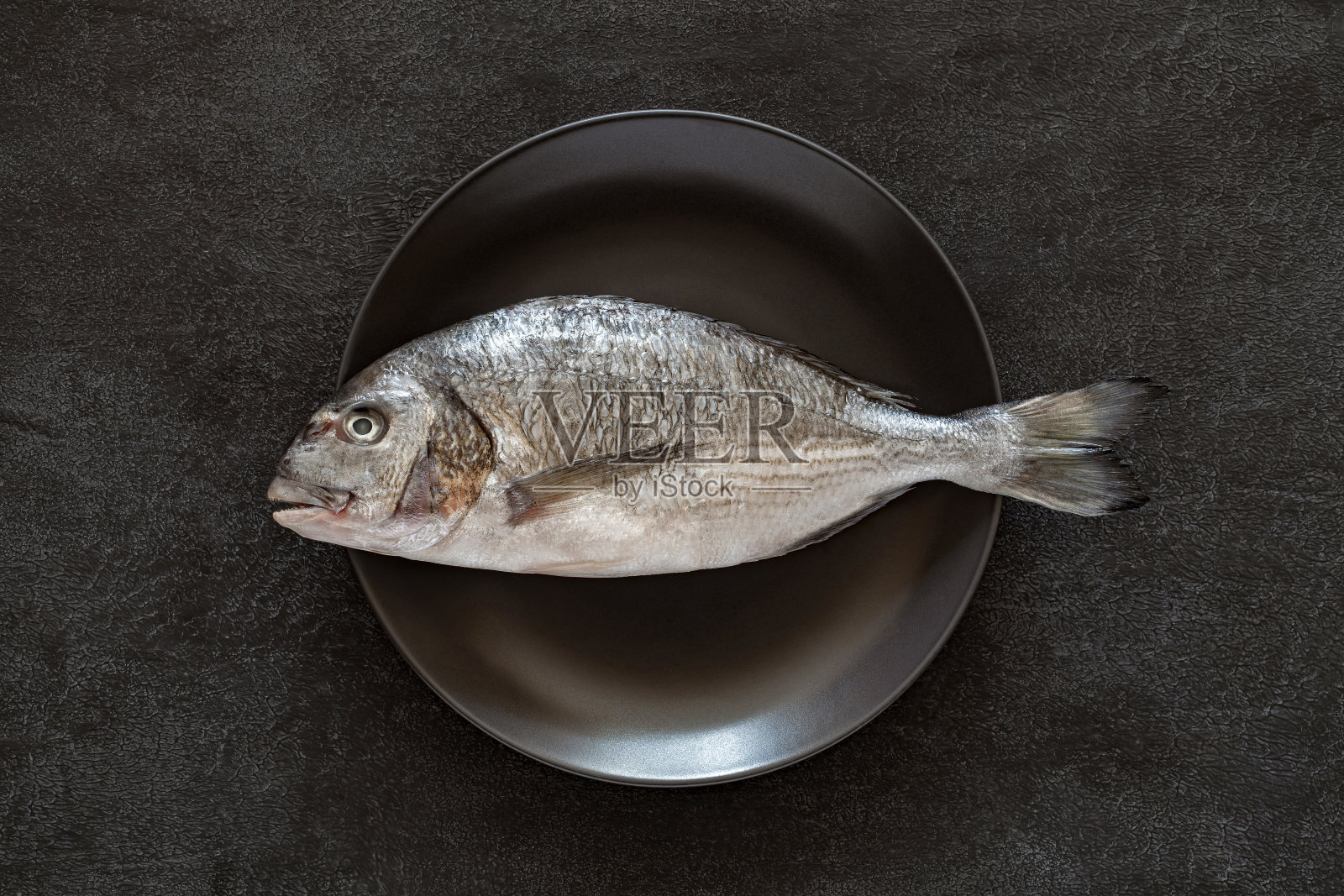 灰色盘子上生的新鲜多拉多鱼照片摄影图片