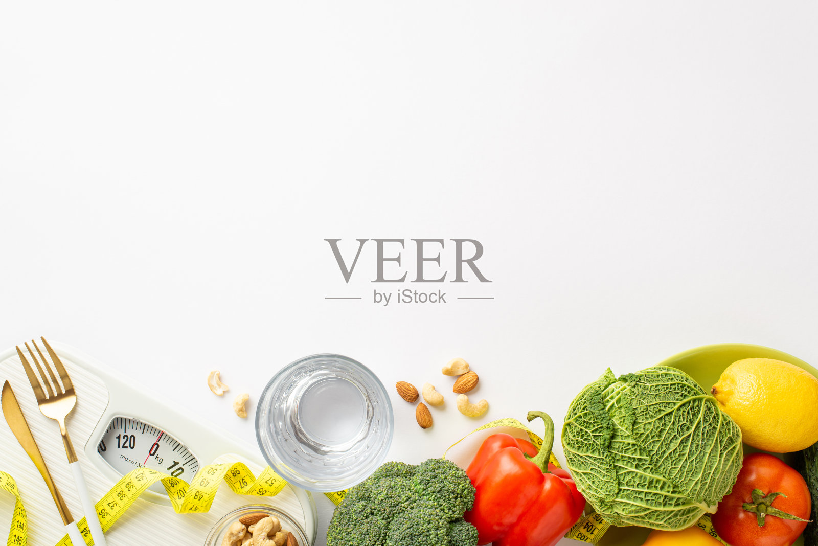 减肥的概念。顶部视图照片玻璃杯的水蔬菜花椰菜卷心菜柠檬番茄辣椒坚果鳞片刀叉和卷尺在孤立的白色背景与空白照片摄影图片