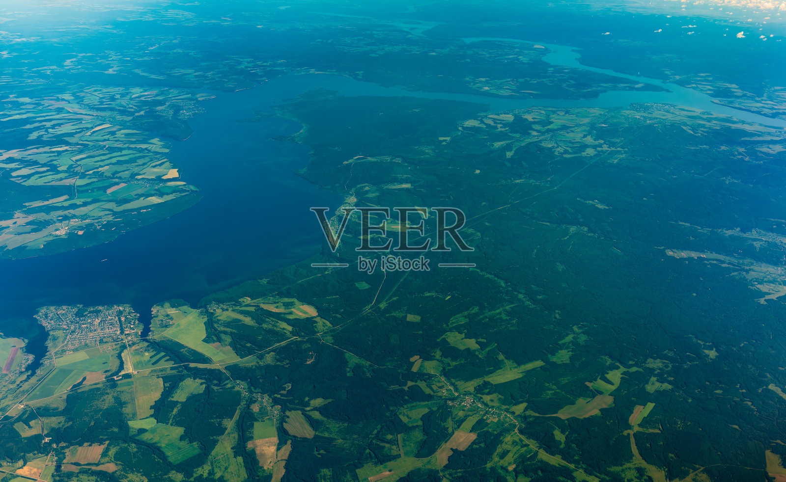 从绿色地面上的飞机窗口鸟瞰。从飞机窗口看到日出时美丽的云照片摄影图片